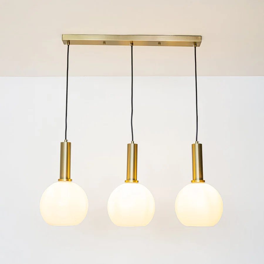 White glass and gold metal pendant lights showcasing stylish designs for contemporary home decor.