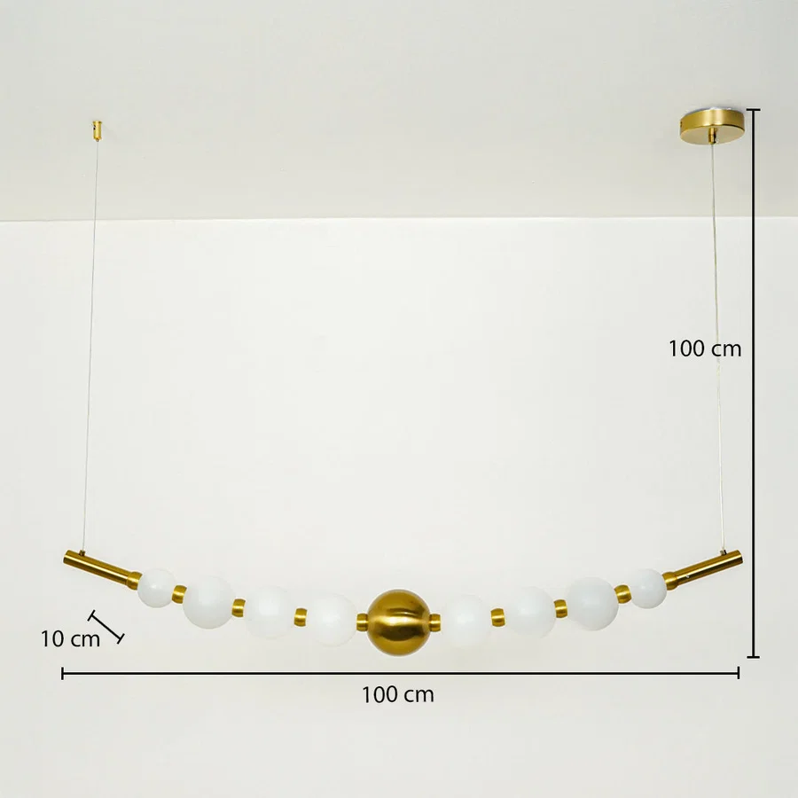 Modern linear pendant light with white glass globes and gold accents suspended on cable 100 cm width 100 cm height 10 cm depth ideal for dining or kitchen lighting.