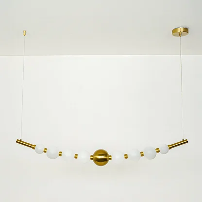 Stylish linear hanging light with multiple white glass globes and gold accents on neutral wall background perfect for modern dining or kitchen lighting.