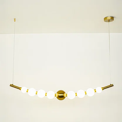 Minimal gold pendant light with white globe shades arranged in linear design on clean neutral background ideal for contemporary home lighting.