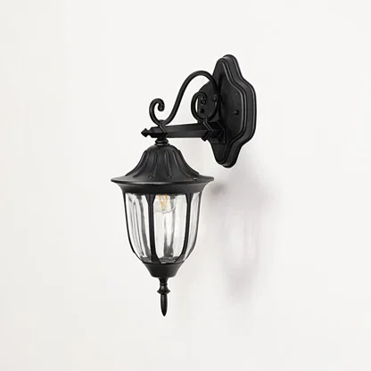 Black outdoor wall sconce turned off on white background showcasing downward lantern with curved glass vintage design.