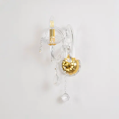 Crystal wall light with golden base and drops elegant wall mounted table lamping on off white background.