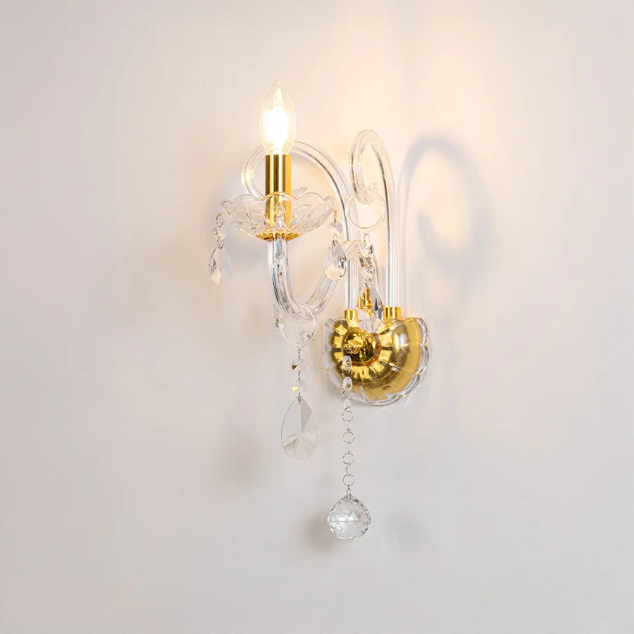 Modern crystal wall light in gold finish with hanging crystals for bedroom or living decor lighting white background.