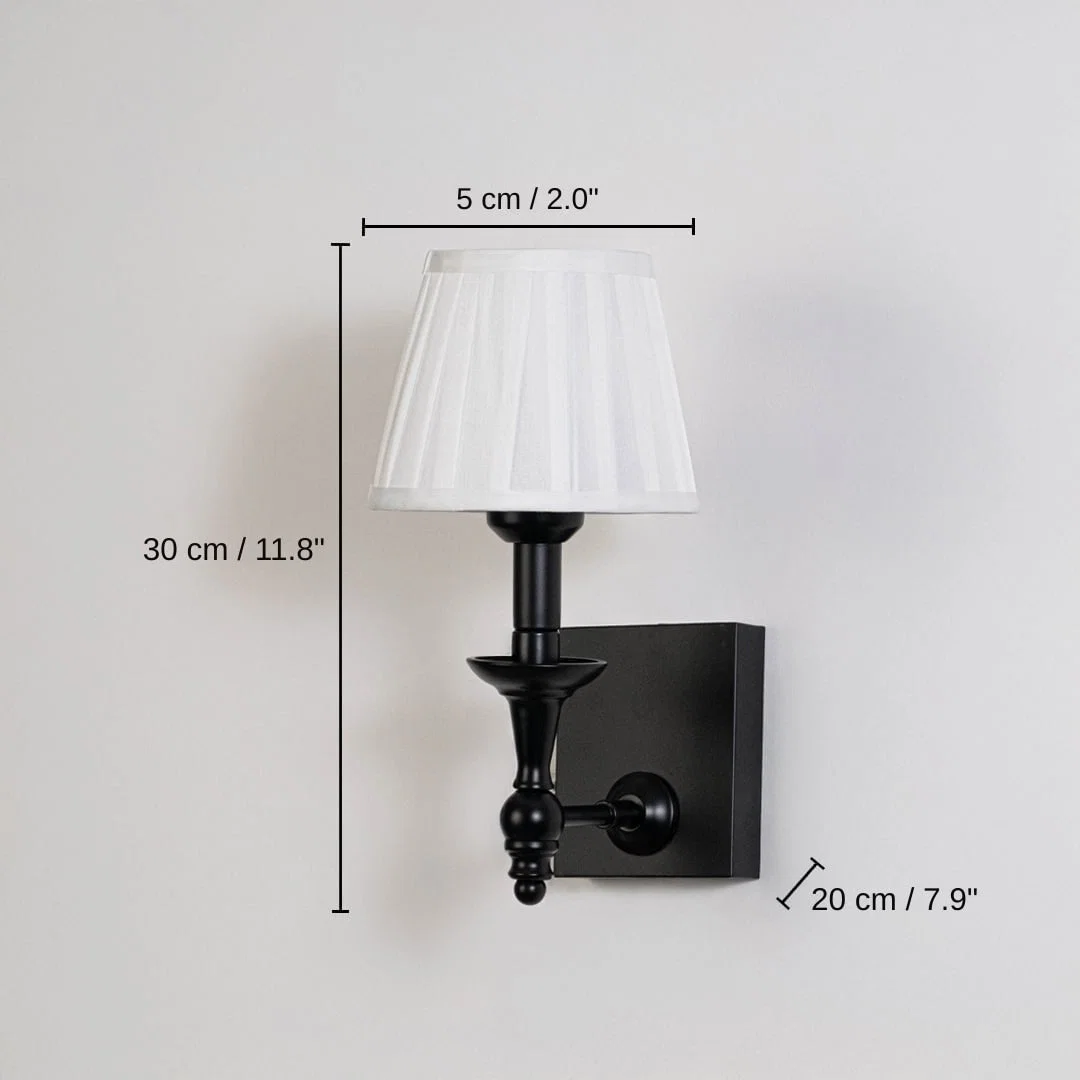 Black metal wall sconce with white pleated shade, base 30 x 5 x 20 cm (11.8 x 2.0 x 7.9 inches), canopy 12 x 10 cm (4.7 x 3.9 inches) dimensions
