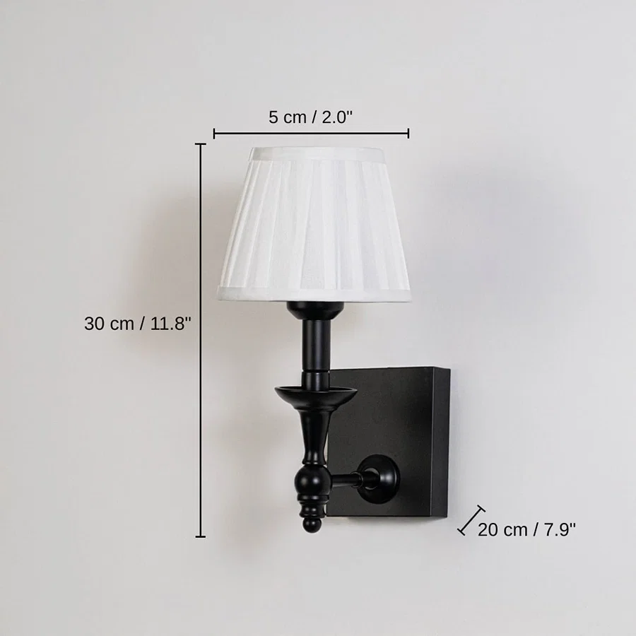 Black metal wall sconce with white pleated shade, base 30 x 5 x 20 cm (11.8 x 2.0 x 7.9 inches), canopy 12 x 10 cm (4.7 x 3.9 inches) dimensions