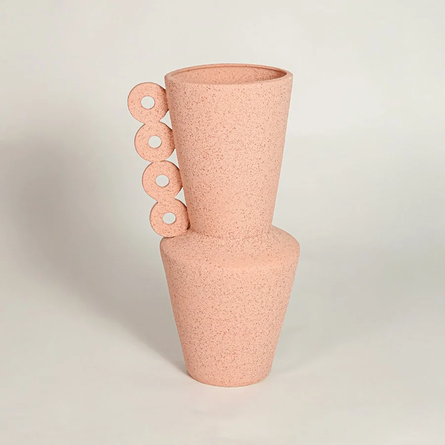 Peach decorative textured ceramic vase on white background modern home decor accent piece for table floor console styling.