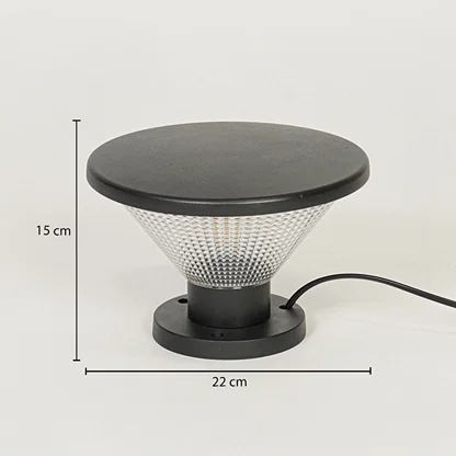 Contemporary outdoor surface light with black metal top and textured glass diffuser on neutral background 15 cm height 22 cm width ideal for garden or pathway lighting.

