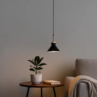 Black metal pendant light above side table adding Scandinavian elegance and warm ambient lighting to cozy interiors.