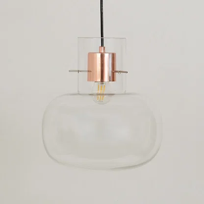 Clear glass pendant light with rose gold metal fitting for dining room kitchen island on white background image.