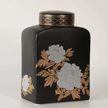 Black ceramic jar with gold and white floral artwork in a front view perfect for luxury décor styling and statement home accents.