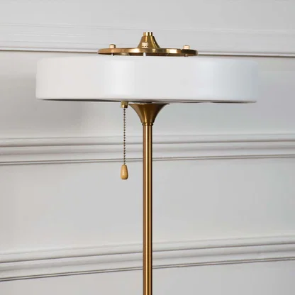 White metal table lamp top showcasing refined craftsmanship with pull chain detail and elegant modern design accents.