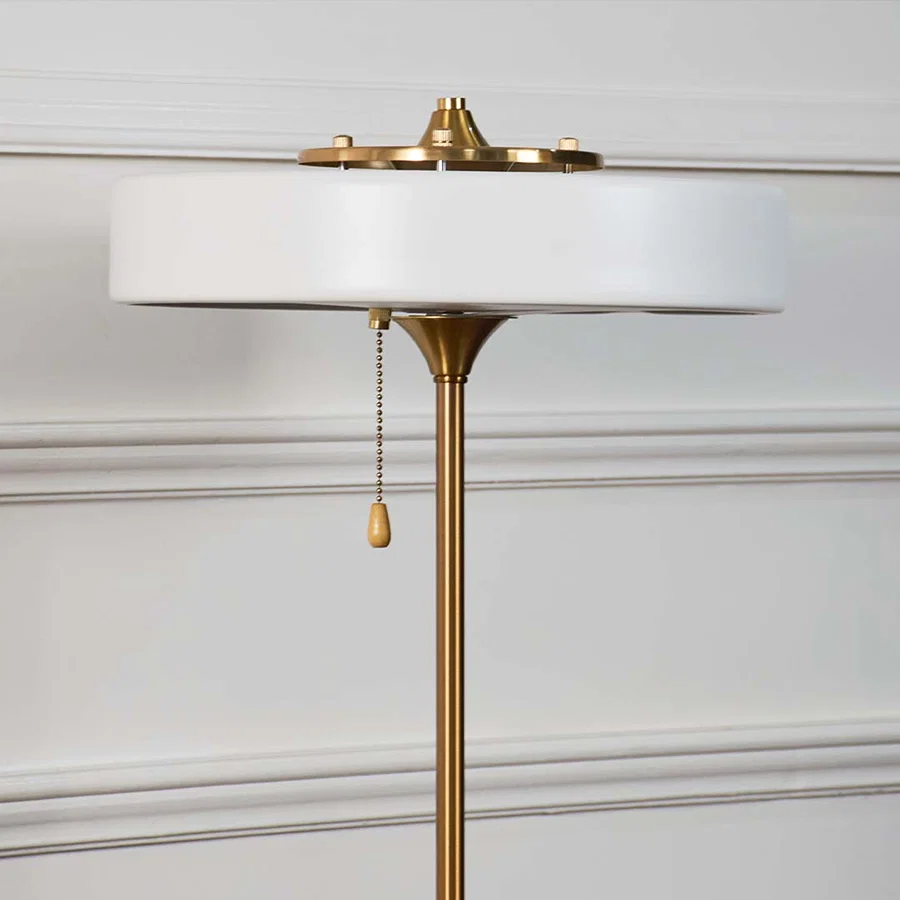 White metal table lamp top showcasing refined craftsmanship with pull chain detail and elegant modern design accents.
