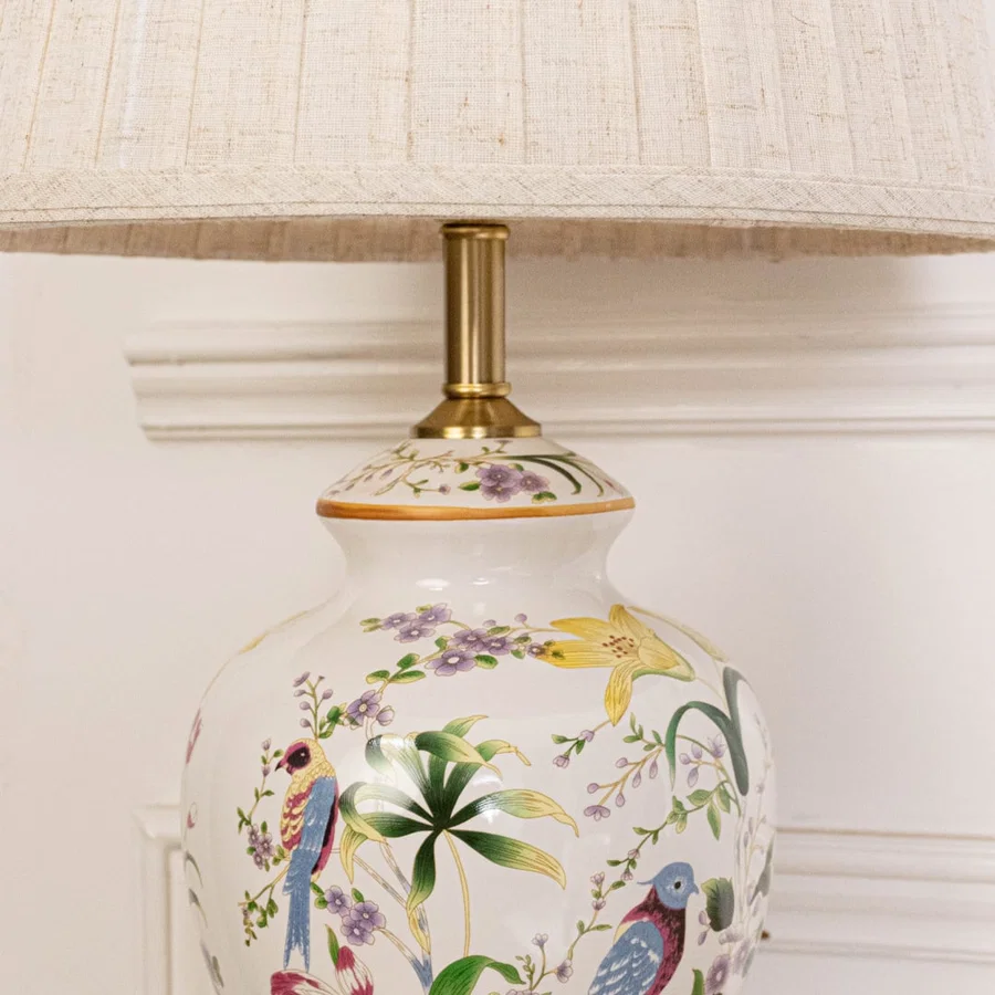 Close view of ceramic table lamp showcasing floral art and golden detailing reflecting premium craftsmanship and sophisticated design appeal.