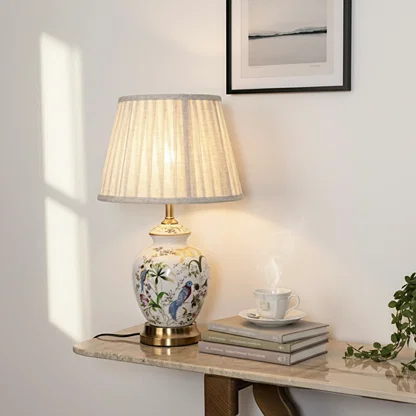 Floral ceramic table lamp with pleated fabric shade styled on a wall shelf adding warm classic decor lighting.