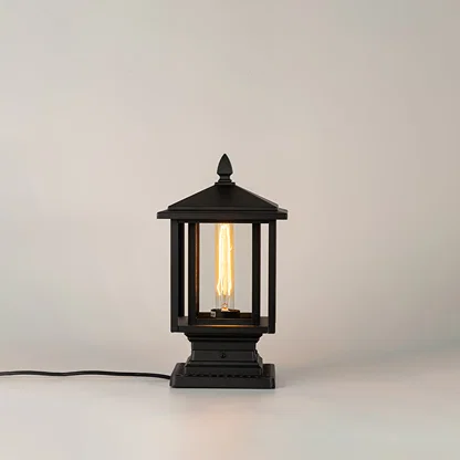 Black outdoor gate light with warm glowing bulb for modern exterior decor styling use.