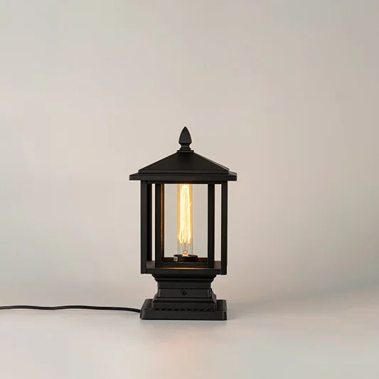 Black outdoor gate light with warm glowing bulb for modern exterior decor styling use.