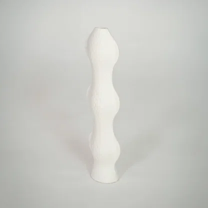 White background image of white ceramic sculptural vase for elegant shelf decor styling with textured finish.