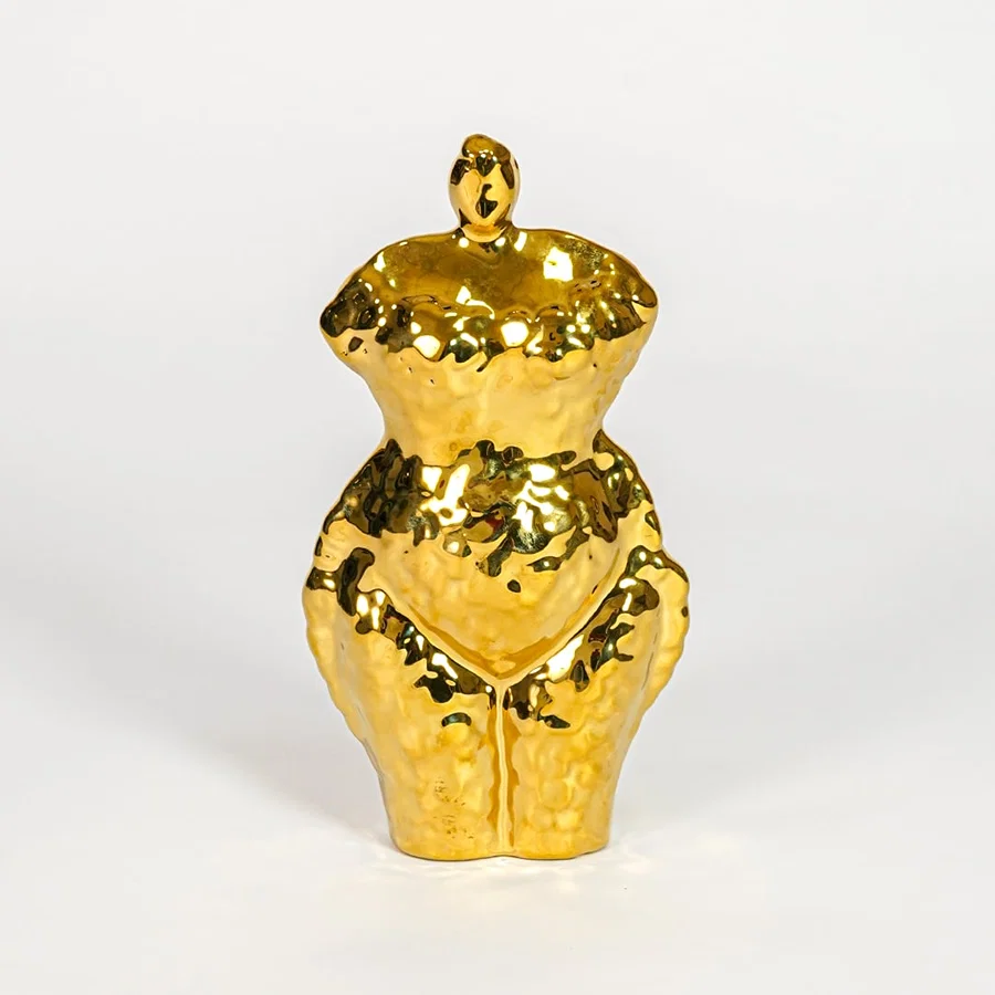 Gold decorative ceramic female sculpture on white background modern home decor accent piece for table shelf console styling.