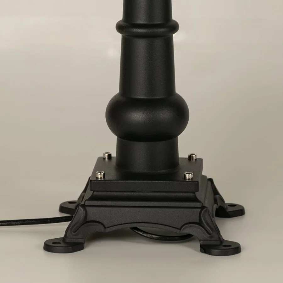 A focused closeup of the lantern top showing the finial structure smooth metal roof and detailed patterned frame that surrounds the frosted glass panel beautifully.