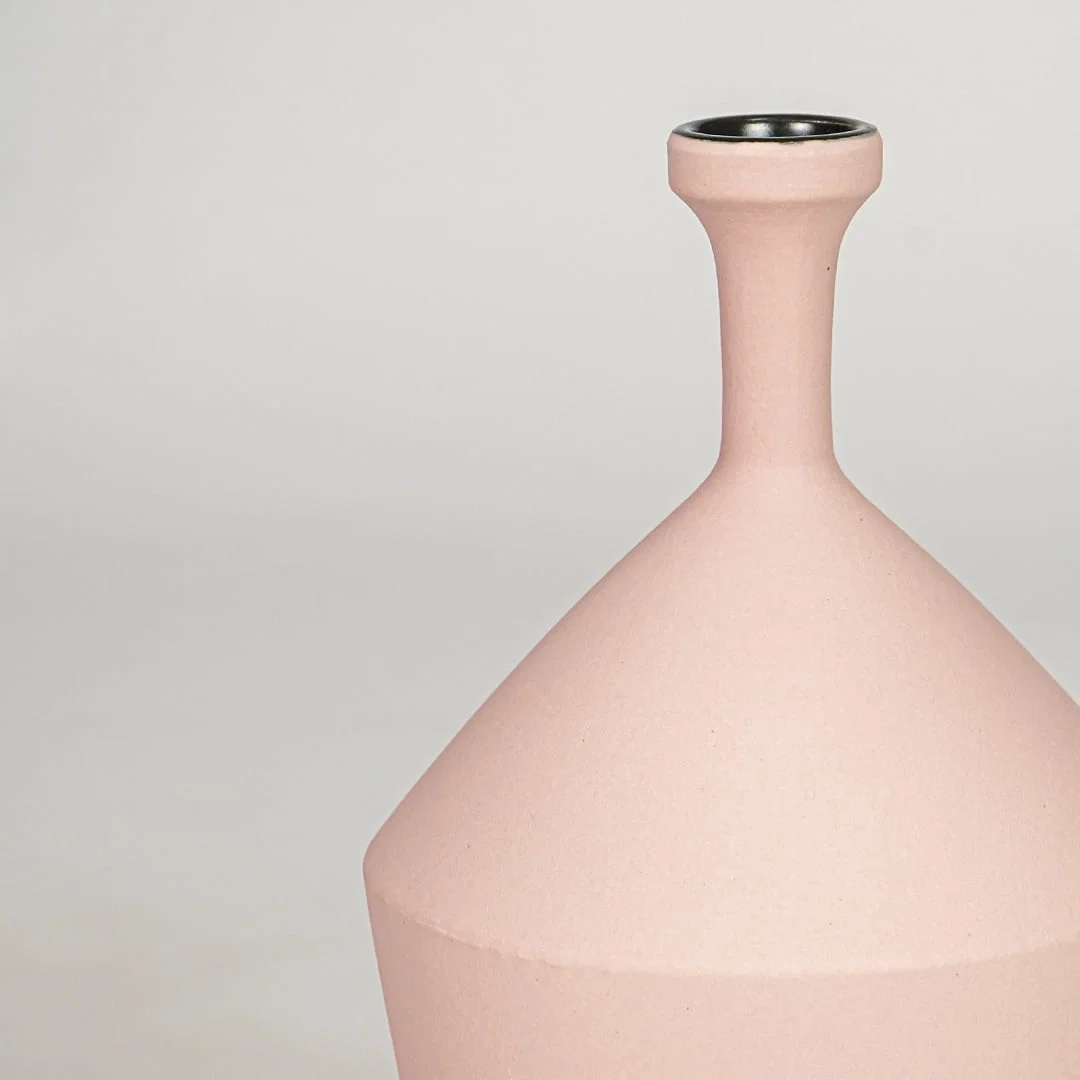 Pink ceramic flower vase closeup modern decorative vase for tabletop shelf console living room decor styling.