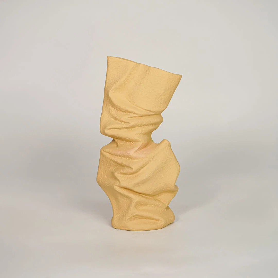 Beige ceramic decorative vase with abstract twisted design for modern console table and shelf decor placement.