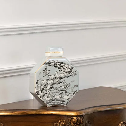 White ceramic decorative jar with black floral artwork displayed on a console table for elegant modern home decor.