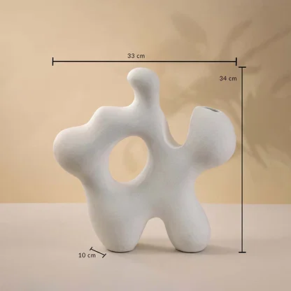 Dimension image of large abstract white ceramic sculpture vase with organic cutouts cast against shadows showing 34 cm height and 31 cm width.