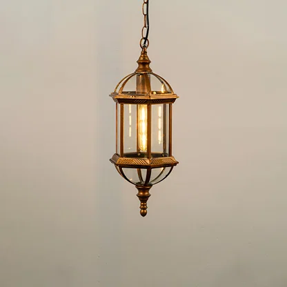 Gold metal hanging outdoor lantern with glass enclosure glowing on white background ideal for porch entrance and exterior decor lighting.