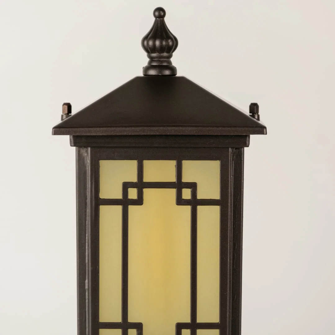 Black outdoor lantern Closeup seeded glass Light On showing warm glow and decorative pebbled glass panels.