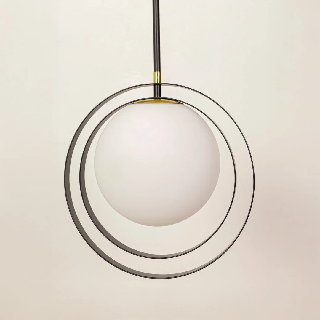 Black and gold metal pendant light closeup highlighting layered circular detailing and premium craftsmanship quality.