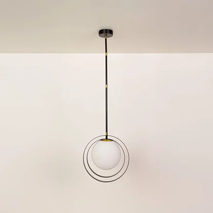 Black and gold metal pendant light with circular acrylic diffuser illuminated to display contemporary ceiling lighting.