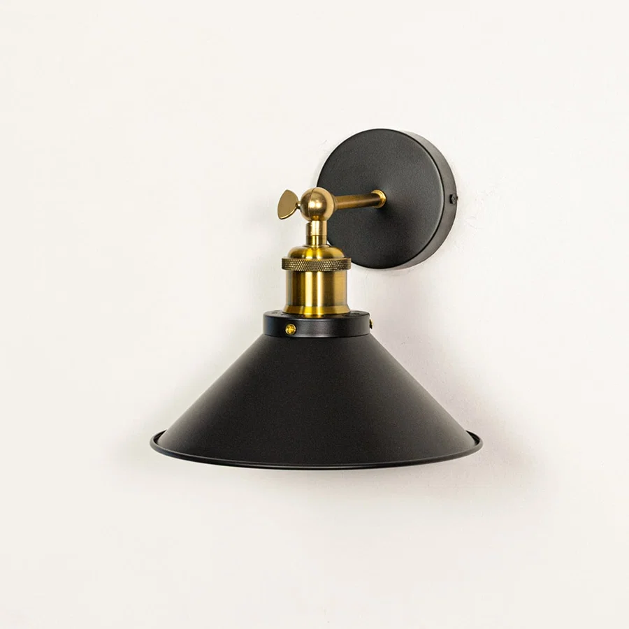 Wall mounted black metal light with gold accents switched off on white background showing matte texture elegant shape and build quality.