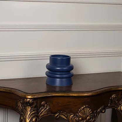 Deep blue ceramic vase with sculpted round layers shown on a clean white background highlighting its smooth matte finish and modern shape.
