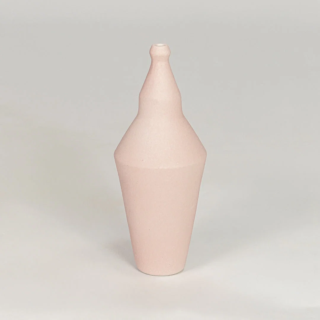 Matte pastel pink tapered sculptural vase for artistic modern home decor and unique interior shelf display style.